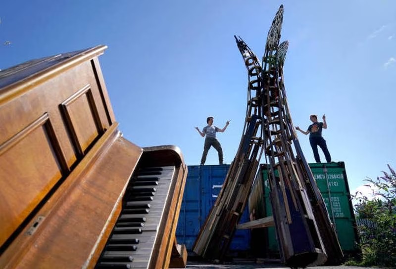 Matt Wright and Tim Vincent-Smith pose with one of their upcycled sculptures made from abandoned pianos. Photo: Getty